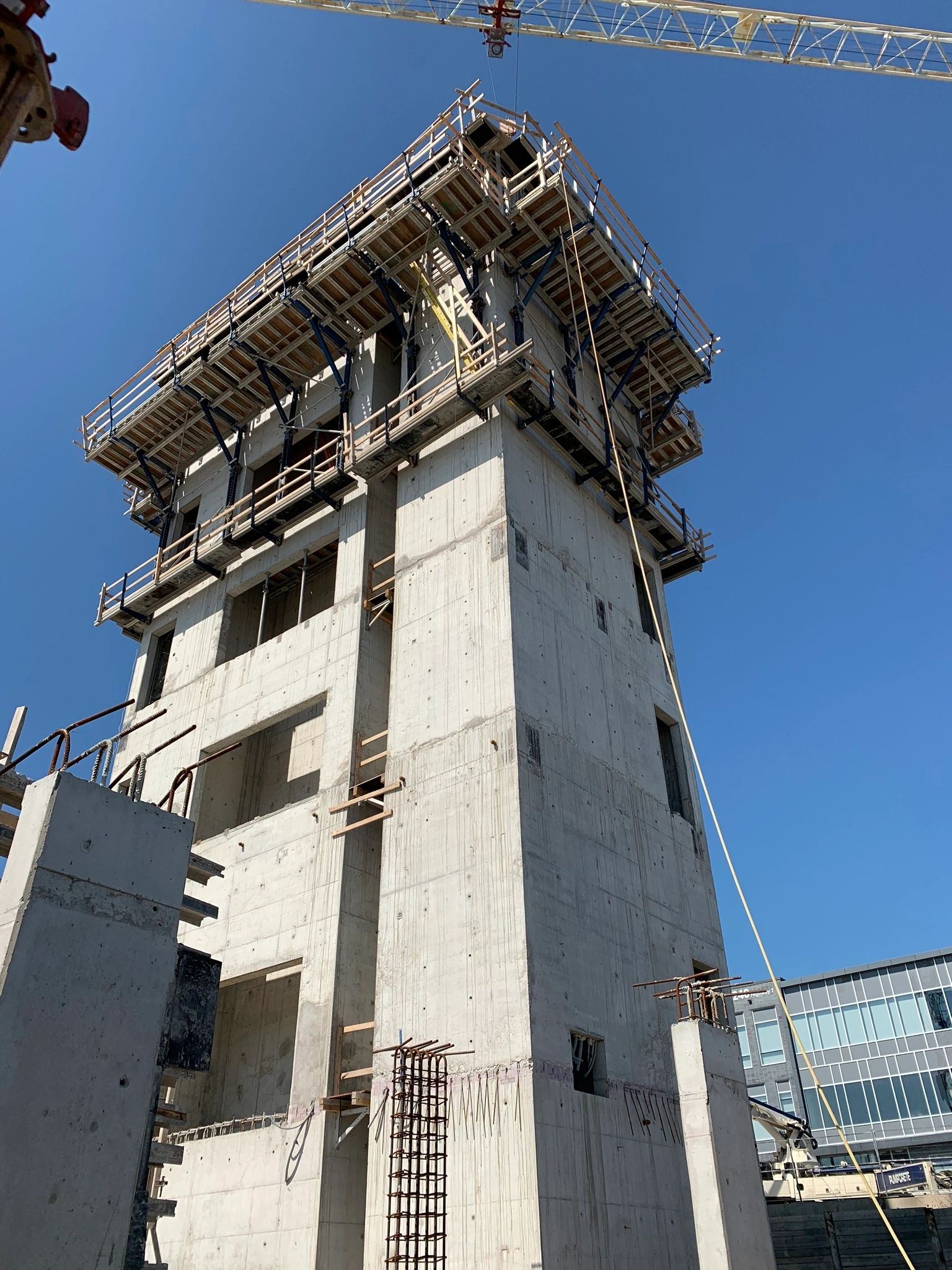 Climbing formwork on a concrete stair and elevator core against a blue sky