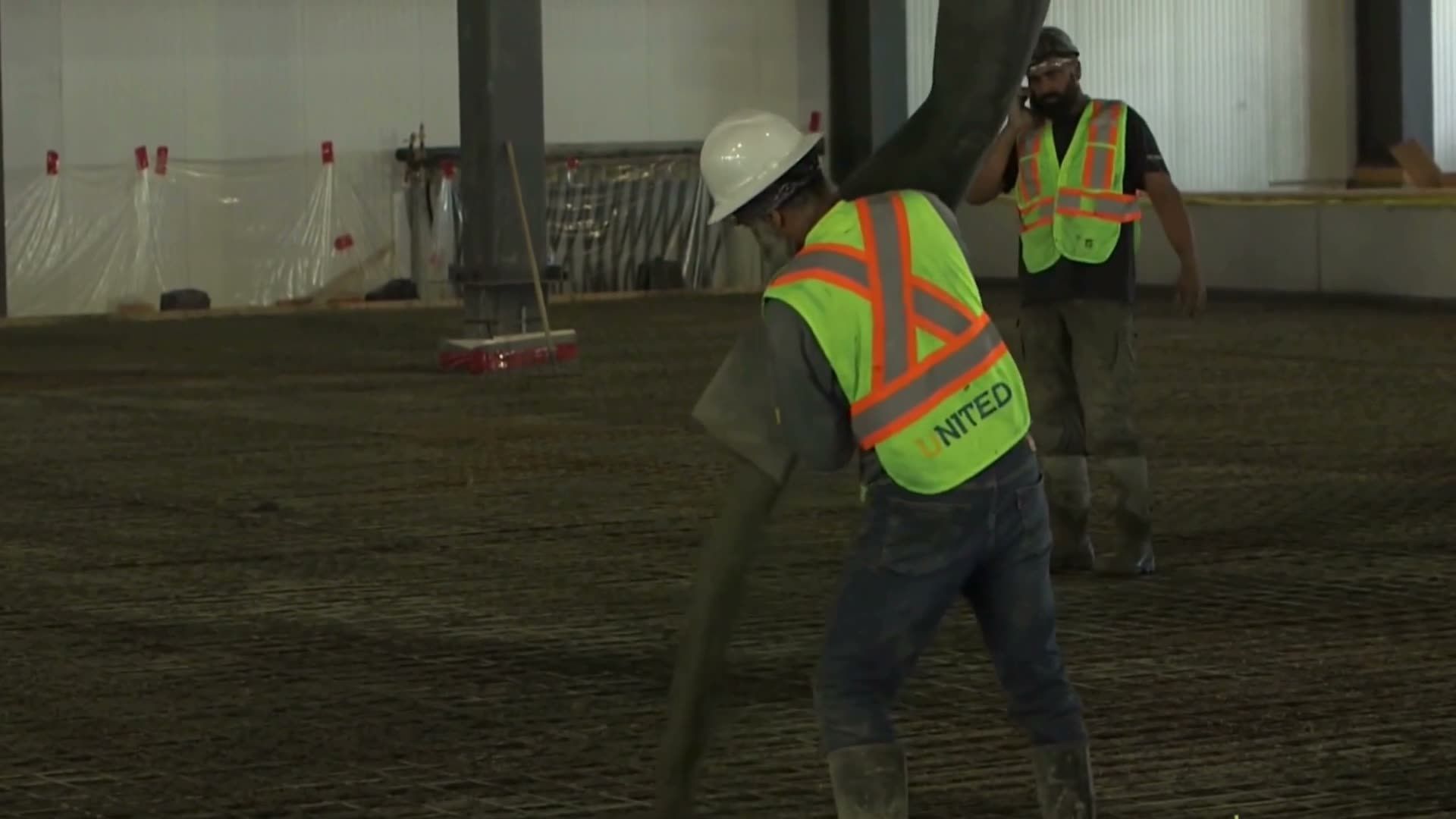 A laser screed head pulling fresh concrete level