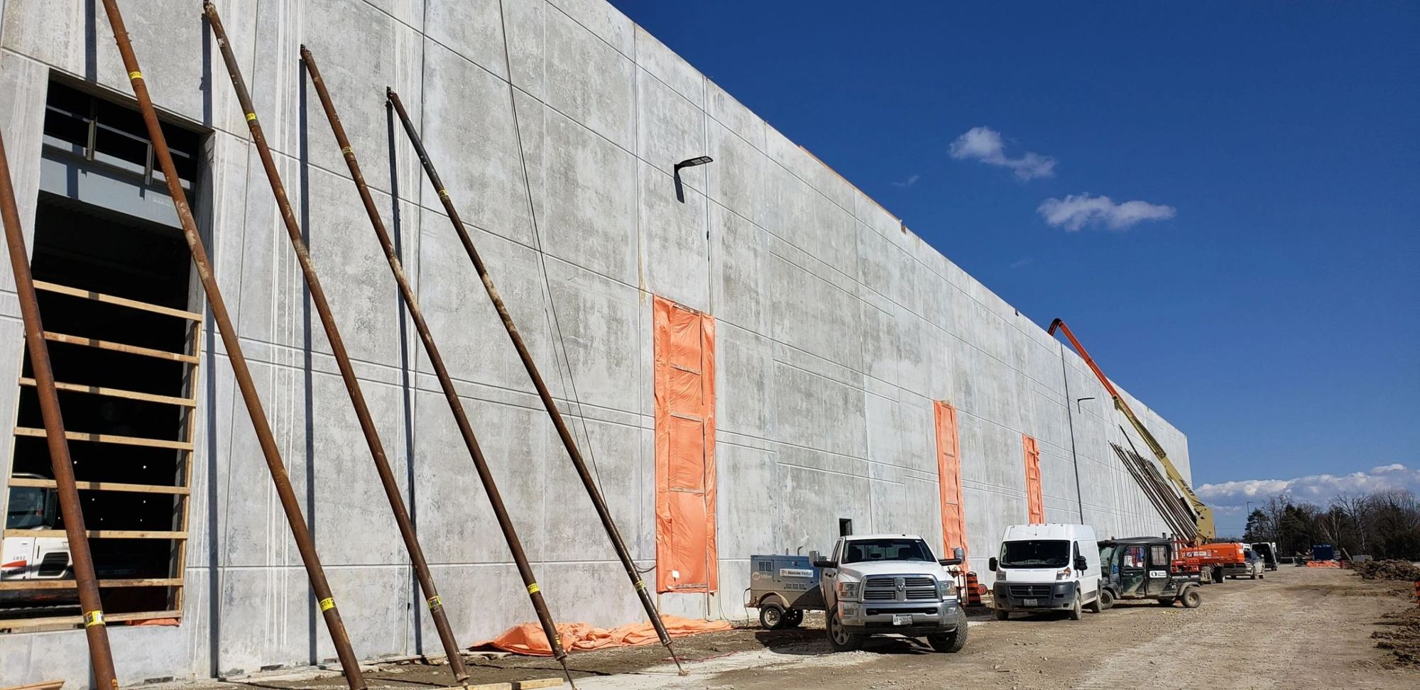 Concrete wall panels braced along a new industrial building